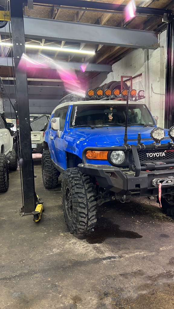 Blue Toyota FJ Cruiser off-road build with lifted suspension, bumper, winch and auxiliary lighting at Falcon Garage