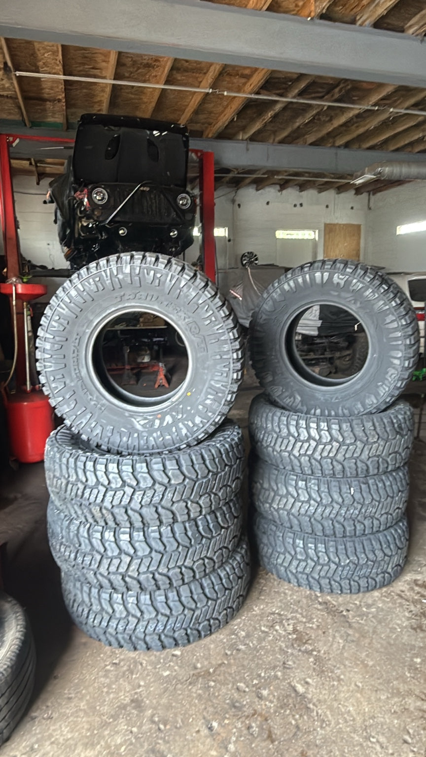 Oversized off-road tires prepared for professional installation at Falcon Garage