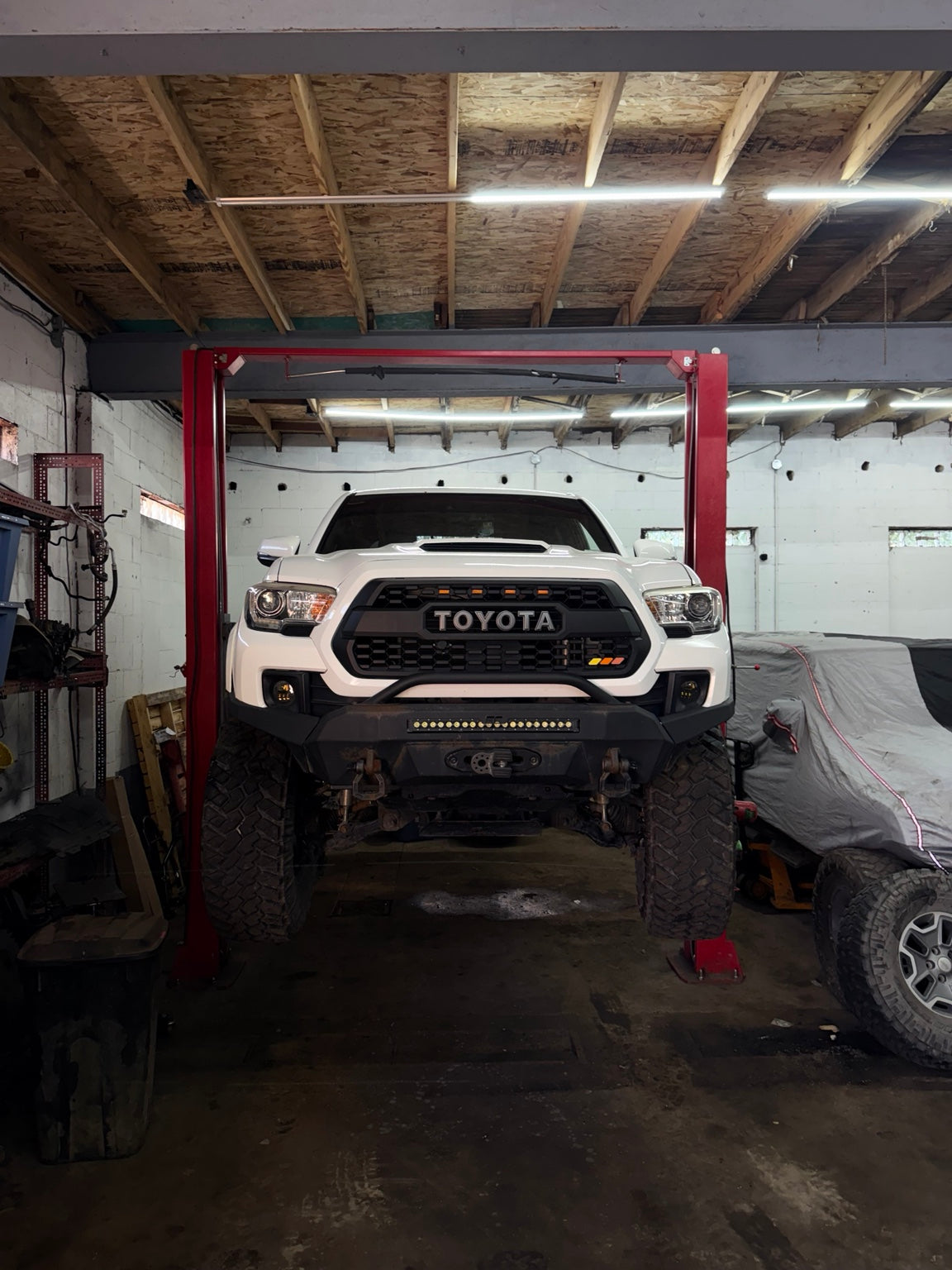 White Toyota Tacoma with lift kit, off-road bumper, winch and LED lighting at Falcon Garage in Columbus, Ohio