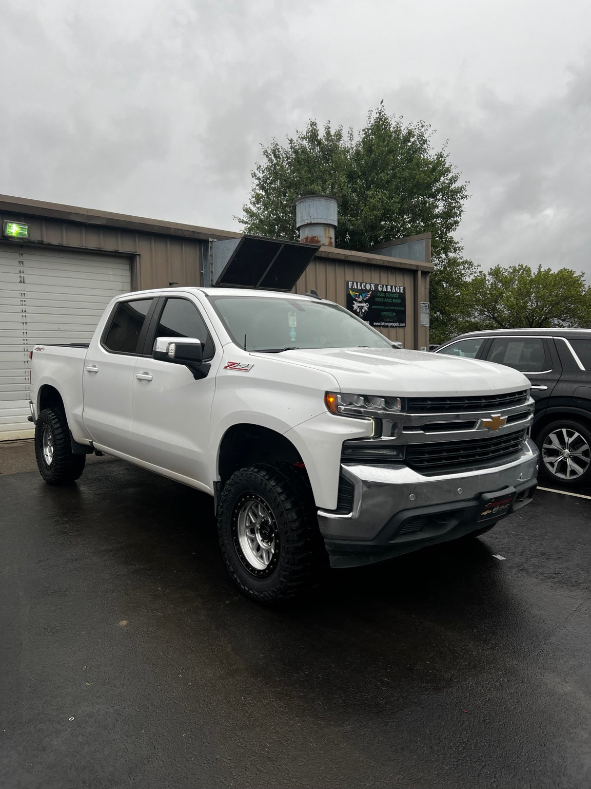 Lifted Chevrolet Silverado with off-road wheels outside Falcon Garage in Columbus, Ohio